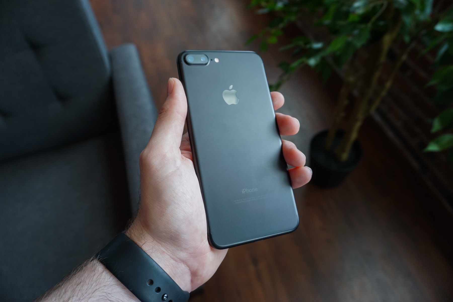 main tenant un smartphone, écran allumé, pour une recherche en mobilité