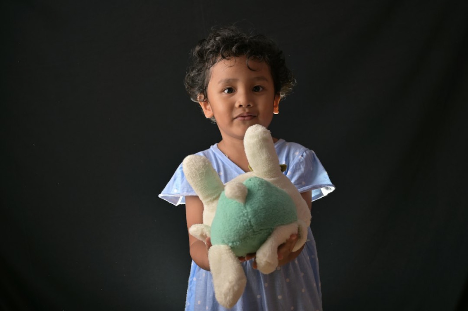 Une peluche tenue dans les mains d'un enfant