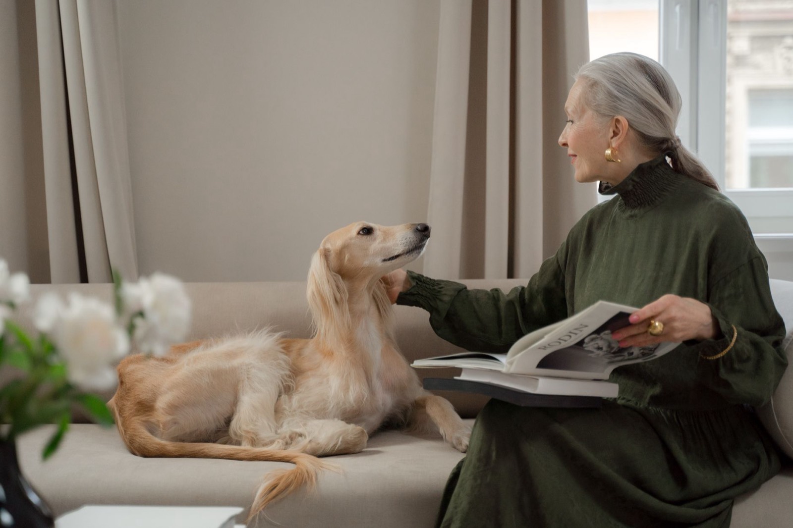 Femme senior assise sur un canapé avec un chat sur les genoux
