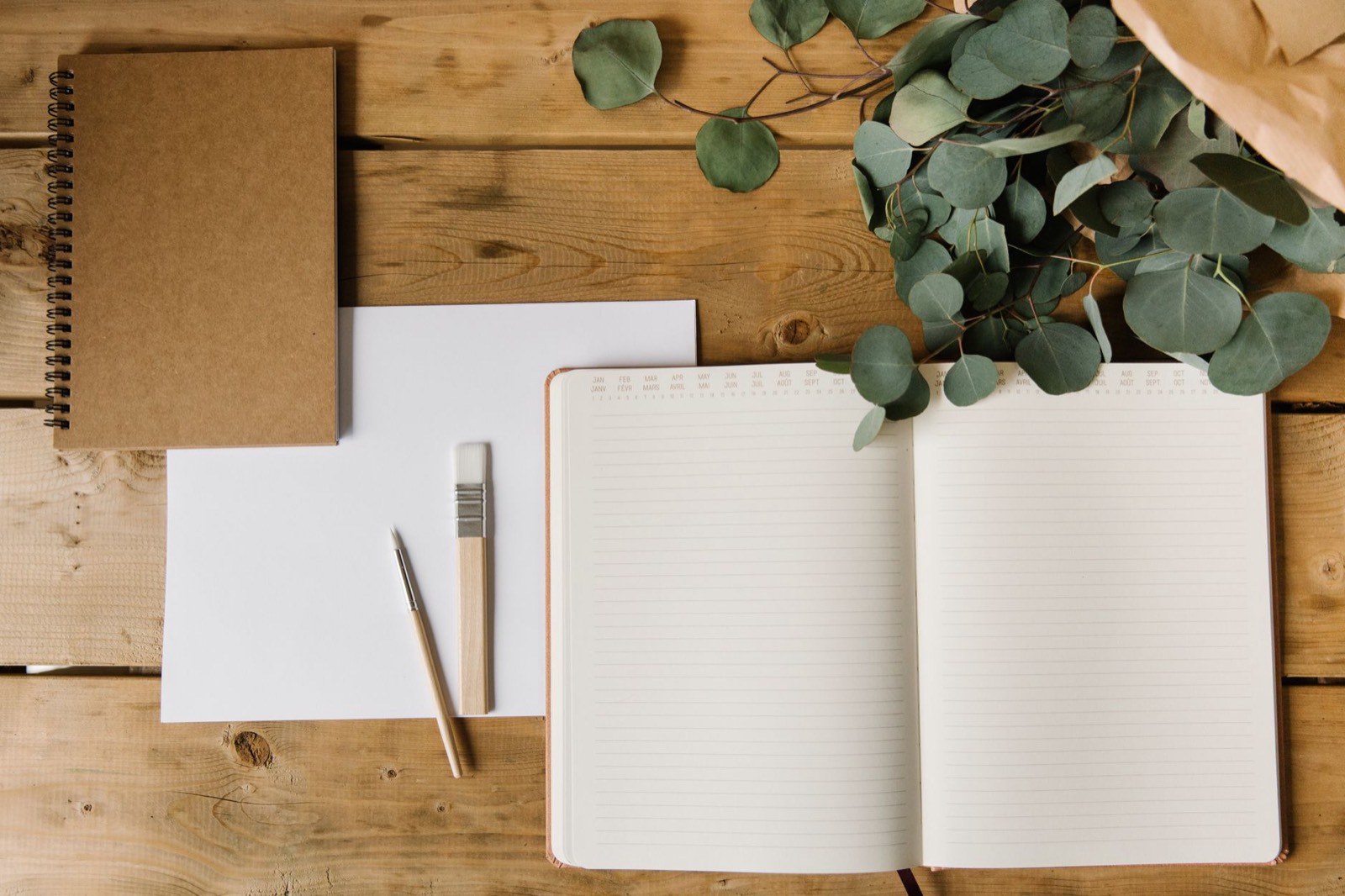 échantillons de stylos en bambou et carnets posés sur une table