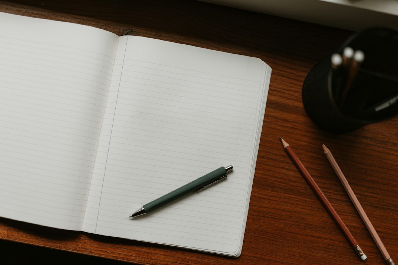 Stylo en bambou et carnet posés sur un bureau en bois